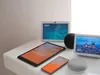 A collection of smart home devices, including smart displays, a smart speaker, a tablet, and a smartphone, are arranged on a white surface. Produktbild-Vorschau