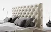A close-up view of a tufted headboard and pillows on a bed. Náhled obrázku produktu
