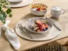 A breakfast setting with French toast, fruit, and coffee on a wooden table. Produktbild-Vorschau