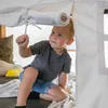 A young boy is playing inside a tent. Produktbild-Vorschau