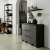 A modern living room or studio space with a dark gray dresser, a black shelving unit, and art supplies. Anteprima dell’immagine prodotto