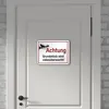 A sign indicating video surveillance is attached to a white door. Produktbild-Vorschau