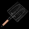 A grill basket with a wooden handle, isolated on a black background. Náhled obrázku produktu