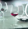 A close-up shot of a wine glass filled with red wine, with another empty wine glass and a decanter in the background. Produktbild-Vorschau