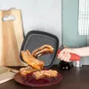 A hand is holding a red spray bottle over a grill pan with ribs, next to a cutting board and a plate of ribs. Náhľad obrázku produktu