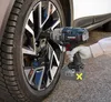 A person is using a cordless impact wrench to tighten a lug nut on a car wheel. Produktbild-Vorschau