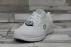 A white Skechers work shoe is shown from a slightly elevated front-left angle against a gray and white wood-plank background. Produktbild-Vorschau