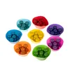 A collection of colorful silicone cupcake liners filled with small colored balls, arranged in a circular pattern. Voir les images du produit
