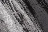 A close-up abstract pattern of a rug with black, gray, and white tones. Produktbild-Vorschau