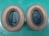 Two ear pads for headphones, labeled L and R, are placed on a green surface. Produktbild-Vorschau