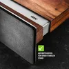 Close-up of the corner of a wooden cutting board with a metal insert and a textured gray side, showing a green checkmark and German text. Anteprima dell’immagine prodotto