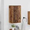 A wooden cabinet mounted on a white tiled wall, with a towel rack and towel to the right, and some bathroom accessories on a shelf below. Náhled obrázku produktu
