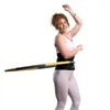 A woman is using a hula hoop with a waist trainer. Produktbild-Vorschau