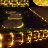 A collage of images showing LED string lights used for outdoor decoration, including along a garden path and on a wooden surface. Produktbild-Vorschau