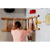 A person is interacting with a wooden ladder mounted on a wall, with a dartboard and other items in the background. Produktbild-Vorschau