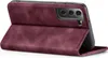 A close-up side view of a burgundy flip-style phone case, open and propped up to display the back of a smartphone with its camera array. Produktbild-Vorschau