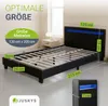 A black bed frame with blue LED lighting in the headboard, shown in a room setting with a nightstand and lamp. Produktbild-Vorschau