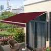 A balcony with chairs, a table, plants, and a maroon awning extended over a sliding glass door. Podgląd zdjęcia produktu