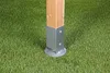 A wooden post secured by a metal bracket to a circular base, resting on artificial grass. Produktbild-Vorschau