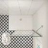 A top-down view of a shower enclosure with a white shower tray and patterned tiles. Produktbild-Vorschau