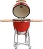 A red ceramic kamado grill with the lid open, shown on a stand with wheels and side shelves. Produktbild-Vorschau