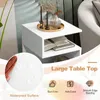 A white S-shaped side table with open shelves, decorated with candles and a vase on top, and books on the shelves. The image also features marketing text and icons highlighting product features. Podgląd zdjęcia produktu