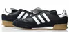 A pair of black Adidas sneakers with white stripes and tan soles are displayed on a white background. Anteprima dell’immagine prodotto