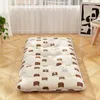 A floor mattress with a cute bear pattern is laid out on a wooden floor in a room with sheer curtains in the background. Produktbild-Vorschau