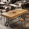 A modern bar area with a wooden high-top table and stools, surrounded by lounge seating. Voir les images du produit