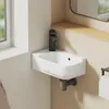 A close-up view of a white ceramic wall-mounted sink with a black faucet in a bathroom. Produktbild-Vorschau