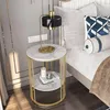 A bedside table with a lamp and books next to a bed. Produktbild-Vorschau
