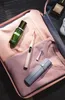 A collection of travel-sized toiletries and clothing items laid out inside an open bag. Voir les images du produit