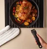 A roasted meat dish with vegetables in a pan, with oven mitts and a pan handle. Voir les images du produit