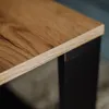 Close-up of a wooden tabletop with a black leg. Anteprima dell’immagine prodotto