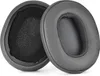 Two dark gray ear pads for headphones are shown against a white background. One ear pad is shown from the side, revealing its inner foam padding, while the other is shown from the front. Anteprima dell’immagine prodotto