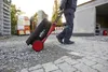 A person is pulling a tool case on wheels across a construction site. Produktbild-Vorschau