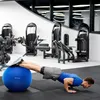 A man performing a push-up exercise with his feet on a blue exercise ball in a gym. Voir les images du produit