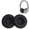 Two black ear pads for headphones are shown in the foreground, with a grey pair of headphones in the background. Produktbild-Vorschau