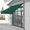 A dark green awning is extended over a sliding glass door on a white building, with a wooden deck in the foreground. Anteprima dell’immagine prodotto