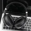 A pair of black headphones rests on a laptop keyboard. Produktbild-Vorschau