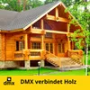 A large wooden house with a porch and stairs, set in a grassy yard with trees. Produktbild-Vorschau