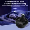 A person sleeping in bed with a close-up of a robot vacuum cleaner wheel in the foreground. Produktbild-Vorschau