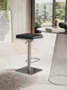 A modern bar stool is shown in a well-lit room with a large window and plants. Produktbild-Vorschau