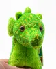 A close-up shot of a green plush toy dragon held by a hand against a white background. Produktbild-Vorschau