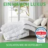 A white duvet is laid out on a bed in front of a window with white curtains. Produktbild-Vorschau