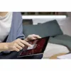 A person is using a tablet device while sitting on a couch. Produktbild-Vorschau