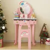 A pink children's vanity table and stool set decorated with rainbows and clouds, placed next to a decorated Christmas tree. Podgląd zdjęcia produktu