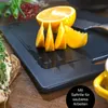 A cutting board with sliced oranges on it, with some greens and berries in the background. Anteprima dell’immagine prodotto