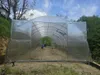 A greenhouse structure on a grassy slope. Produktbild-Vorschau