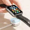 A hand is holding an Apple Watch, which is placed on a wireless charging stand. Produktbild-Vorschau
